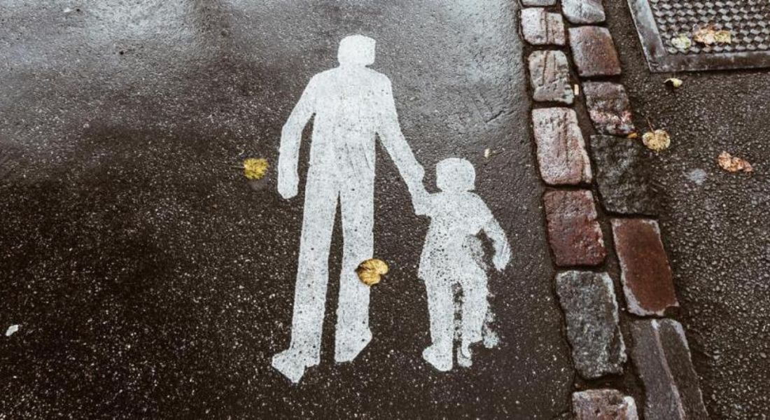 Concrete paint image of two figures, an adult and child, holding hands 